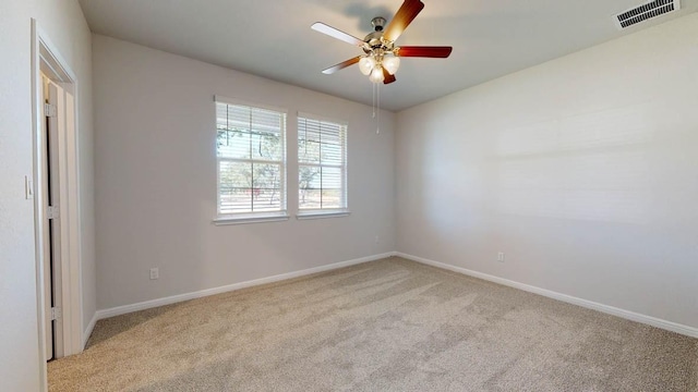 empty room featuring ceiling fan and light carpet