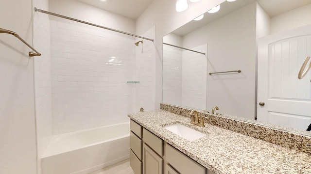 bathroom featuring tiled shower / bath combo and vanity