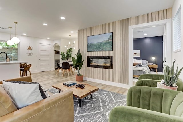 living room with sink, light hardwood / wood-style flooring, and a large fireplace