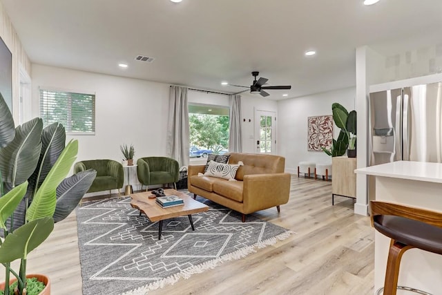 living room with ceiling fan and light hardwood / wood-style flooring