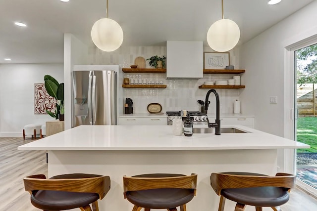 kitchen with hanging light fixtures, stainless steel refrigerator with ice dispenser, backsplash, and light hardwood / wood-style flooring