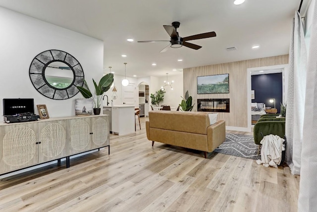 living room with light hardwood / wood-style flooring and ceiling fan