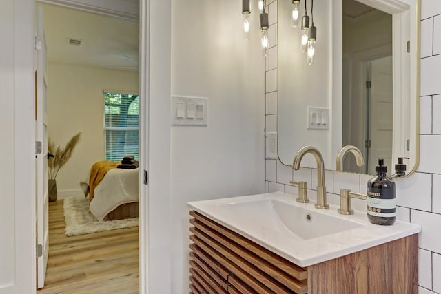 bathroom with decorative backsplash, vanity, and wood-type flooring