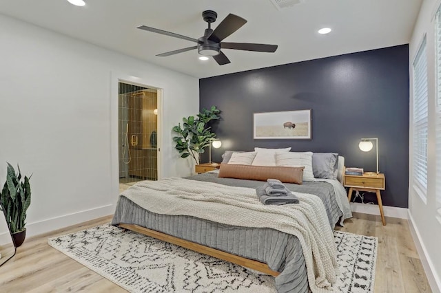 bedroom with ceiling fan, light hardwood / wood-style floors, and ensuite bath