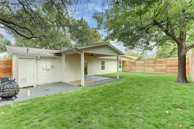 back of property featuring a patio, cooling unit, a yard, ceiling fan, and an outdoor fire pit