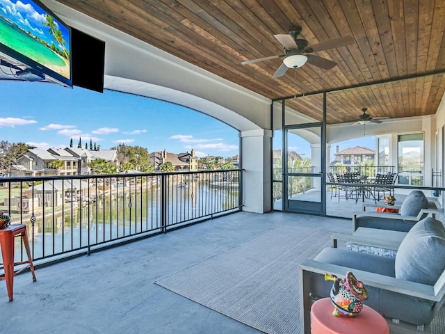 view of patio / terrace with ceiling fan, a balcony, and a water view