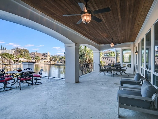 view of patio / terrace featuring ceiling fan and a water view