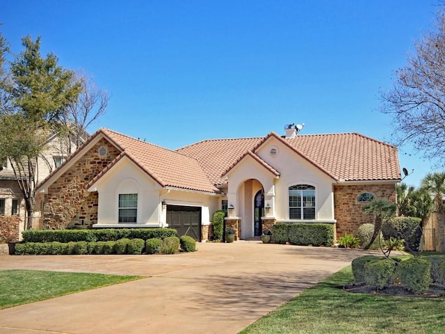 mediterranean / spanish home with a garage