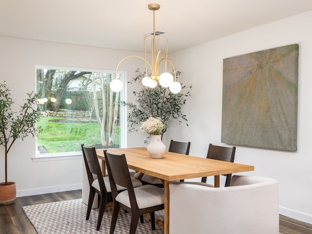 dining room with dark hardwood / wood-style floors and a notable chandelier