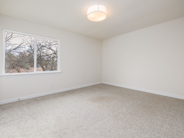 carpeted spare room with baseboards