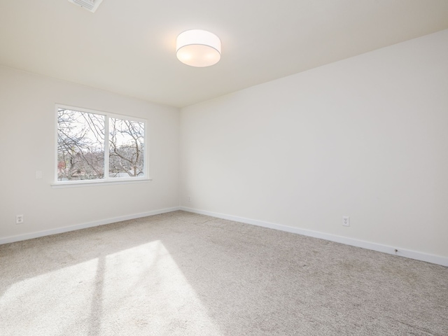 unfurnished room with baseboards and carpet flooring