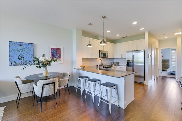 2800 Treble Ln Unit 831, Austin, TX 78704 - kitchen featuring stainless steel appliances, a kitchen bar, a peninsula, white cabinets, and dark wood-type flooring