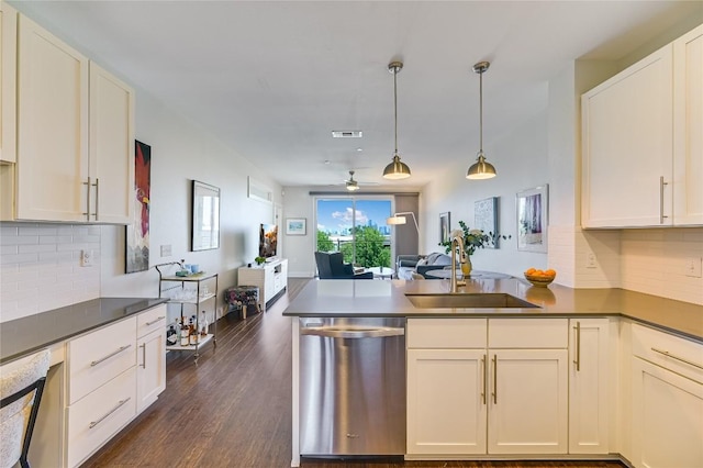 kitchen with decorative light fixtures, sink, white cabinets, stainless steel dishwasher, and kitchen peninsula