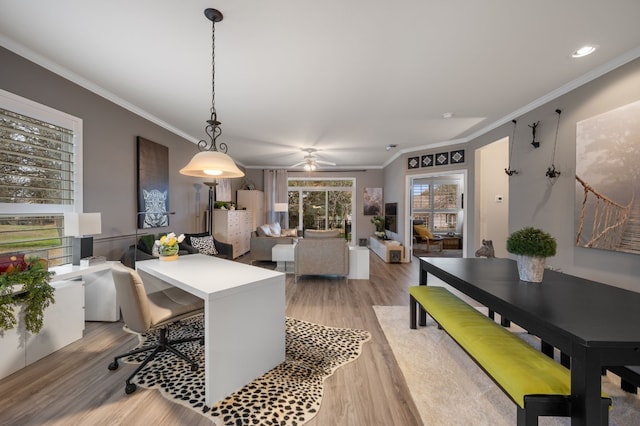 dining area with light hardwood / wood-style flooring and ornamental molding