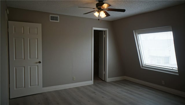 unfurnished bedroom with ceiling fan, a textured ceiling, and light hardwood / wood-style floors