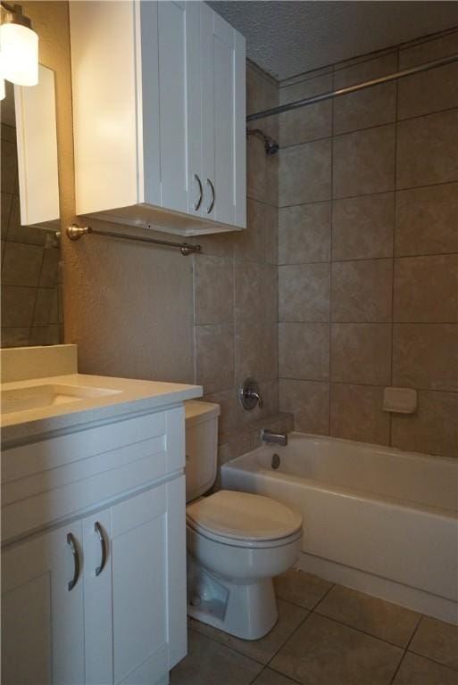 full bathroom with tiled shower / bath, vanity, toilet, and tile patterned floors