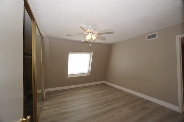 unfurnished bedroom with ceiling fan, hardwood / wood-style flooring, and a textured ceiling