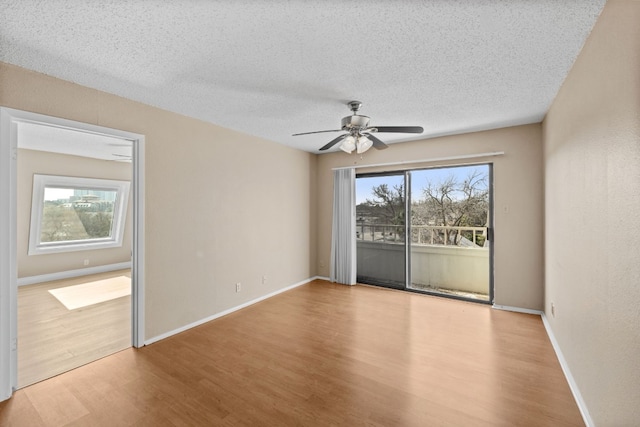 spare room with ceiling fan, light hardwood / wood-style flooring, a textured ceiling, and a healthy amount of sunlight