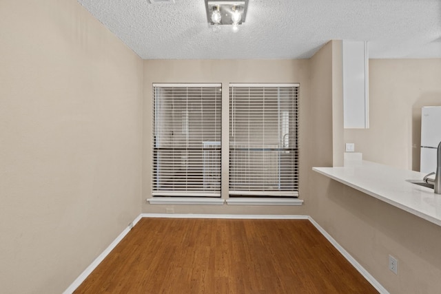 empty room with hardwood / wood-style flooring and a textured ceiling