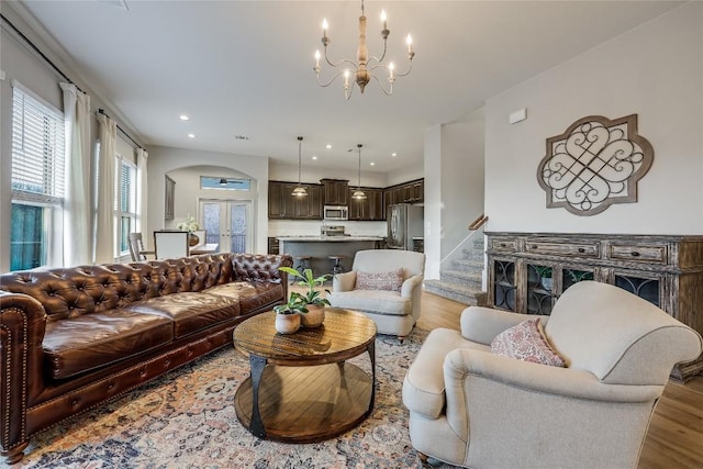 living room featuring a chandelier, light hardwood / wood-style floors, and french doors