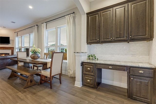 2104 Ringstaff Rd, Leander, TX 78641 - dining space featuring wood finished floors, a lit fireplace, recessed lighting, and baseboards