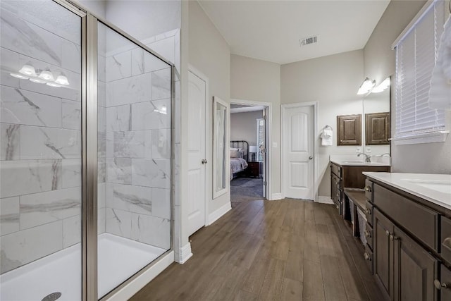 bathroom featuring hardwood / wood-style flooring, vanity, and a shower with shower door