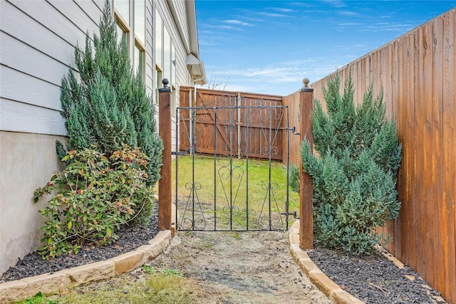 view of gate with a yard