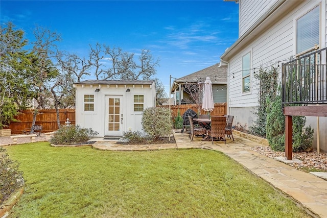 rear view of house featuring an outbuilding, a patio area, and a lawn