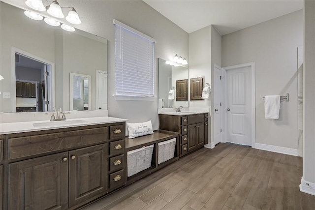 bathroom with wood-type flooring, vanity, and an inviting chandelier