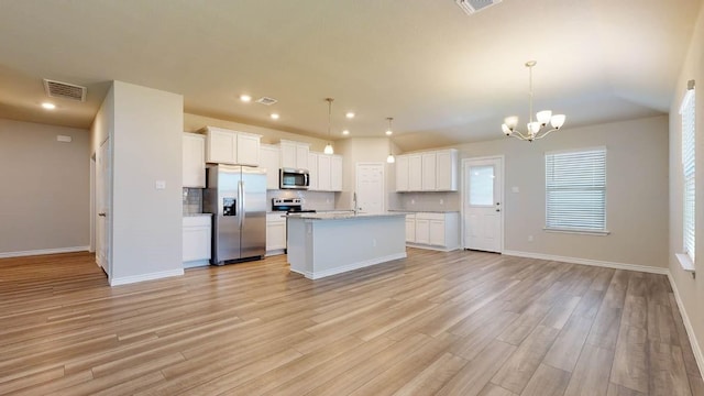 kitchen with white cabinetry, hanging light fixtures, a center island with sink, and appliances with stainless steel finishes