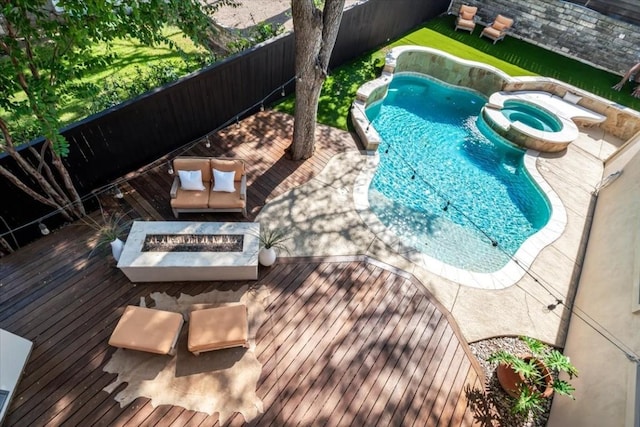 view of pool featuring a wooden deck, an outdoor fire pit, and an in ground hot tub