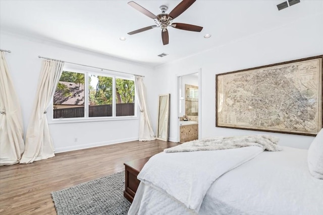 bedroom featuring ceiling fan, hardwood / wood-style floors, and ensuite bath