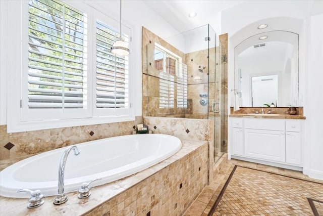 bathroom featuring vanity and independent shower and bath