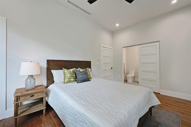 bedroom featuring dark hardwood / wood-style flooring, connected bathroom, and ceiling fan