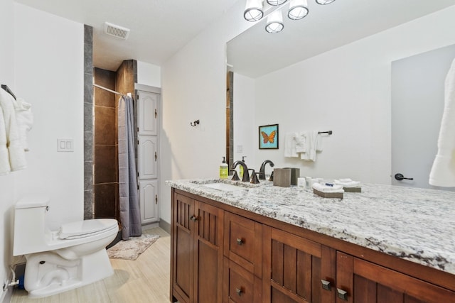 bathroom with vanity, hardwood / wood-style flooring, toilet, and walk in shower