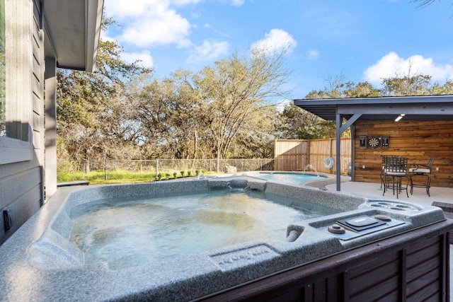 view of swimming pool featuring a hot tub