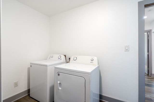 washroom featuring dark wood-type flooring and washing machine and dryer