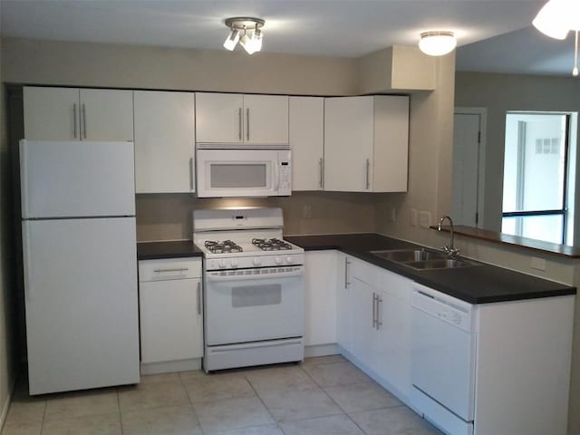 5212 Downs Dr, Austin, TX 78721 - kitchen featuring white appliances, a sink, dark countertops, white cabinetry, and light tile patterned floors