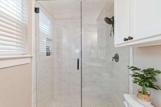 bathroom featuring toilet and a shower with door