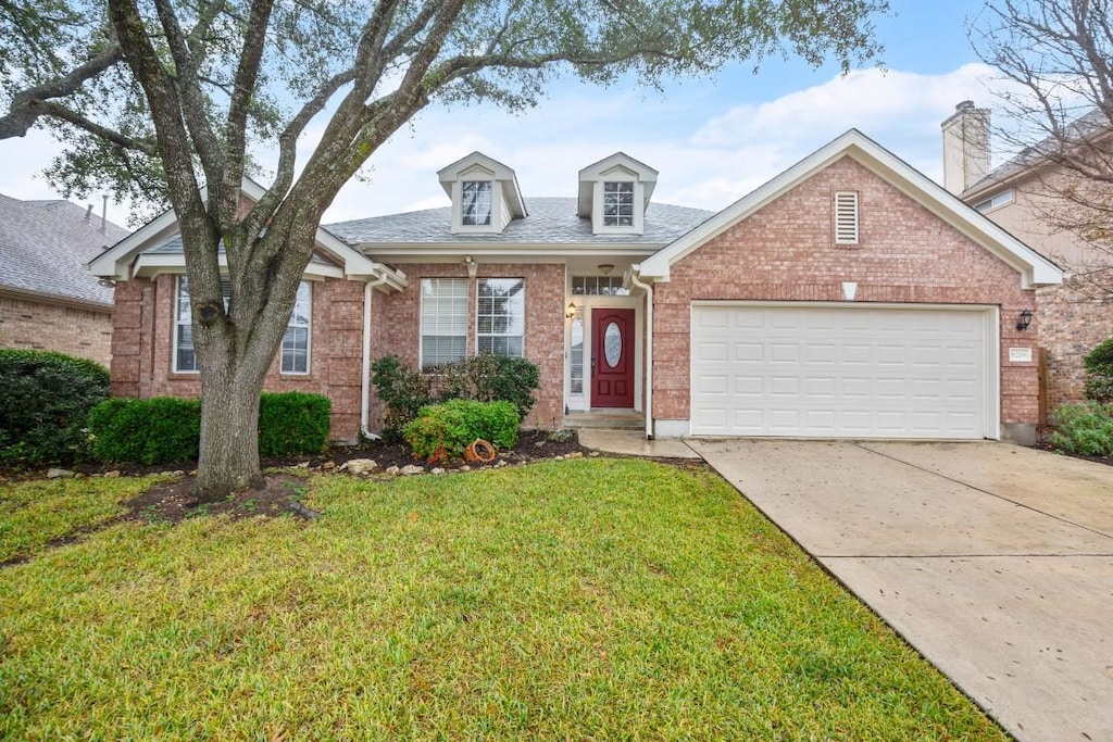 view of front of house with a garage and a front lawn