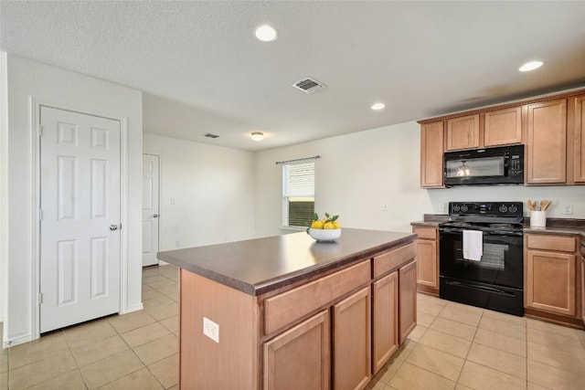 kitchen featuring black appliances, a center island, a textured ceiling, and light tile patterned flooring