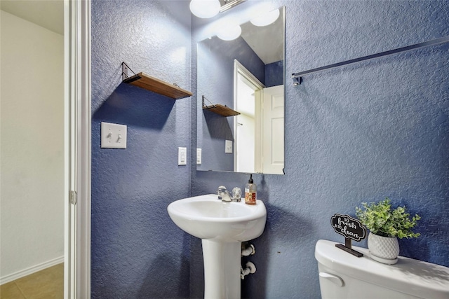 bathroom with tile patterned flooring and toilet