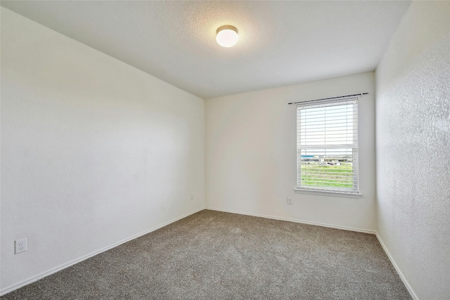 carpeted empty room with a textured ceiling