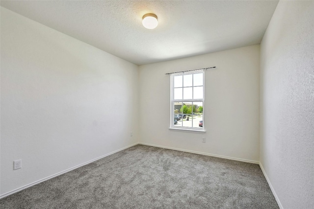 carpeted empty room with a textured ceiling