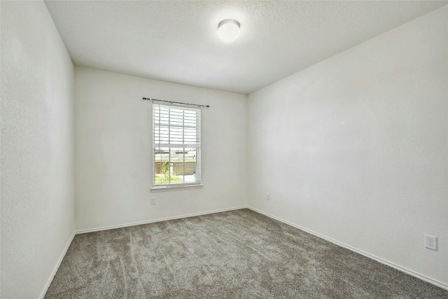 spare room featuring carpet floors and a textured ceiling