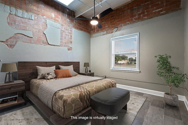 bedroom with ceiling fan and brick wall