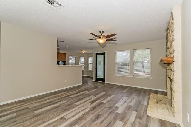6333 La Mesa St, Leander, TX 78645 - unfurnished living room featuring a ceiling fan, dark wood-type flooring, and a textured ceiling