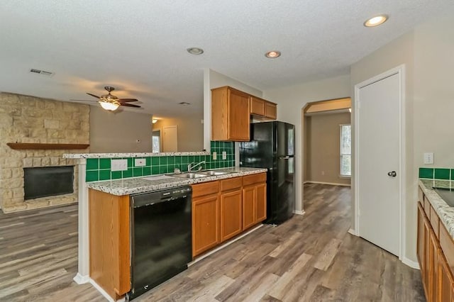 6333 La Mesa St, Leander, TX 78645 - kitchen featuring black appliances, brown cabinets, a ceiling fan, wood finished floors, and recessed lighting