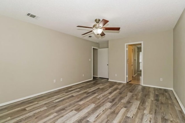 6333 La Mesa St, Leander, TX 78645 - unfurnished bedroom featuring wood finished floors, ensuite bathroom, and ceiling fan