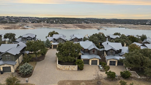 aerial view at dusk featuring a water view